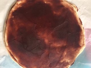 7、豆沙手撕花样面包,把薄饼放在稍大一点的油纸上，方便烘烤的时候不粘，然后在薄饼上涂上一层红豆沙，尽量涂抹均匀。