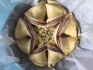 16、豆沙手撕花样面包,在面包胚中间撒少许黑芝麻。