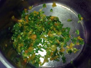 9、田园披萨,开中火，锅内放半小勺玉米油加热，放入青椒碎炒干水分后熄火。