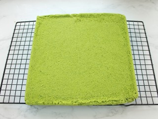 15、抹茶奶油蛋糕卷,倒扣在烤网上取下烤盘，再轻轻撕去油纸晾凉