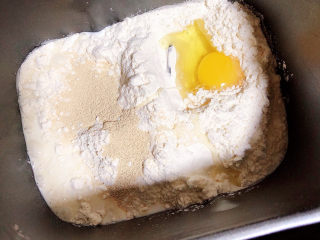 1、虾仁培根披萨,面包机中放入高筋面粉、鸡蛋、牛奶、酵母粉，开始和面。