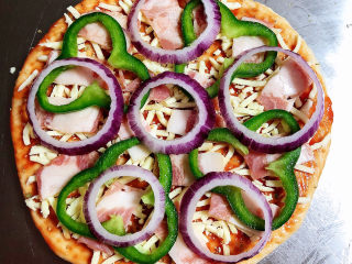 14、虾仁培根披萨,将青椒和洋葱摆放均匀。