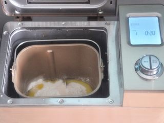 1、水果披萨,面包桶内依次加入水、牛奶，倒入面粉，一角放盐、另一角放糖。在面粉上挖个坑放入酵母，选择和面程度，揉面20分钟，启动程序。