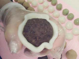 14、冰皮月饼#中秋食饼记#,用手把冰皮捏成四周薄中间略厚的圆片，取馅料放进冰皮中包好捏紧