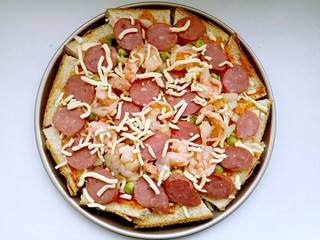 9、吐司披萨,再撒少许的芝士碎。