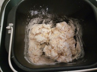 3、自制火腿肠披萨,再把它放到面包机里,开启和面程序八分钟,这是和了3分钟,