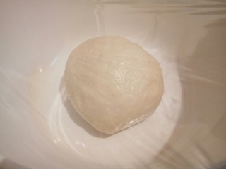 5、自制火腿肠披萨,和好的面团,盖上保鲜膜,放温暖处发酵两倍大(我是下班回家和的面,最近天很热所以只用了一个小时不到就发酵好了。)