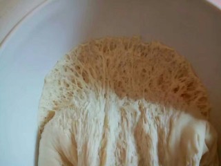 7、自制火腿肠披萨,发酵好的面团用手拉开来看一下,有很多蜂窝状的。