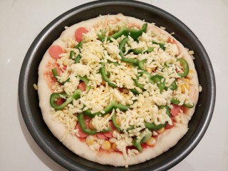 15、自制火腿肠披萨,再放火腿肠,烤香肠,玉米粒,灯椒,再马苏里拉奶酪