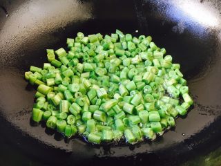 7、四季豆时蔬丁虾仁小炒,热锅凉油放入四季豆,小火多煸炒一会儿。