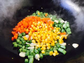 9、四季豆时蔬丁虾仁小炒,当四季豆煸炒至9成熟放入胡萝卜粒和玉米粒,翻炒均匀。