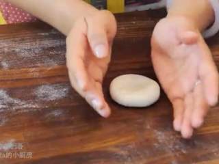 13、酥皮鲜肉月饼,加入肉馅，用勺子按压，包起来接口朝下按扁，转成圆形