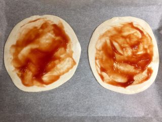 5、快手鸡蛋火腿飞饼披萨,在飞饼皮上抹一层番茄酱，留出边缘不抹。