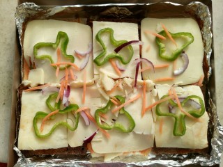 7、吐司披萨,把之前预留的配料摆在上面。烤箱200度预热10分钟后放入烤箱中层烤5分钟。