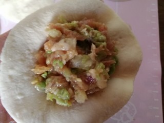 28、中式点心+钱袋白菜肉包,拿一个擀好的包子皮儿，放入馅，