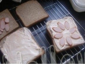 3、茄汁奶油吐司披萨,番茄酱倒入奶油中搅拌均匀，火腿肠切片铺到面包上