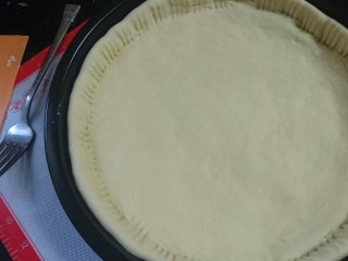 6、培根火腿披萨,发好的饼皮入模具，用小叉子压紧边缘