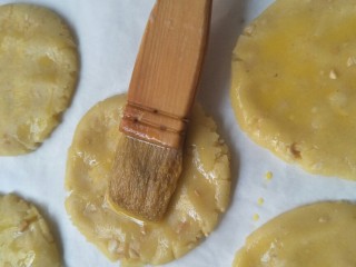10、香脆可口～花生仁版桃酥,剩下的蛋液用刷子刷在桃酥的表面。
