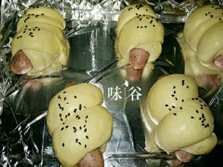 12、黑椒火腿肠面包,发酵好后刷上蛋液，洒上黑芝麻，放在中层，上下火180度25分钟即可。