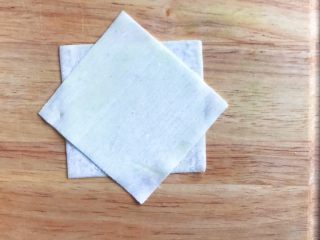 4、馄饨皮蛋奶挞,把另一张馄饨皮交叉叠在上面，如图所示……