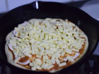 13、铸铁锅基础披萨,撒满奶酪碎。