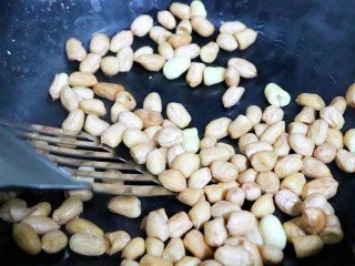 4、超下酒菜之香菜花生米,再把花生米倒入锅中，小火把水分炒干