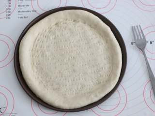 4、自制培根披萨,用叉子叉一些小孔。