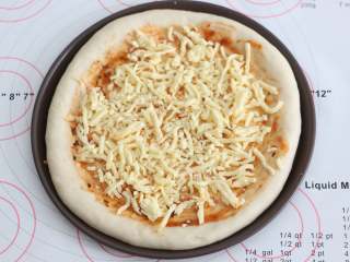 6、自制培根披萨,再撒一层芝士碎。