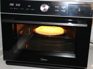 7、自制培根披萨,烤箱200度提前预热，预热好后将披萨饼底放入烤箱中层，烤3分钟。