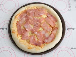 9、自制培根披萨,将培根均匀的铺在烤好的饼底上。