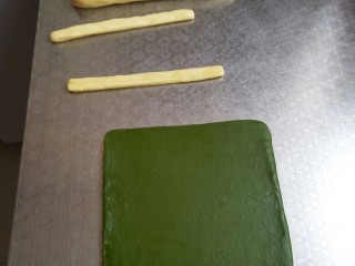 12、兔兔曲奇饼干,将绿色面团擀成17厘米左右的正方形，原味大面团揉成17厘米的圆柱形，两个小面团揉成17厘米的长条做兔耳朵，全部放入冰箱冷冻20分钟后取出，冷冻冷冻冷冻