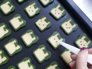 18、兔兔曲奇饼干,把饼干铺在烤盘上，用黑芝麻装饰眼睛嘴