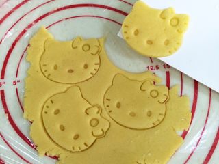 10、hellokitty饼干,用刮板把饼干片转移到铺好油纸的烤盘上。