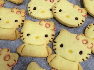 15、hellokitty饼干,继续用红色和黄色的巧克力分别给hellokitty画上蝴蝶结和嘴巴的轮廓。
