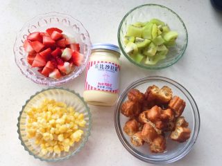 4、缤纷水果油条沙拉,把水果去皮切成小块，用刀切下玉米粒，水里煮一下捞出备用