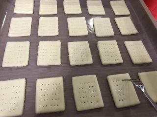 7、柠檬芝士夹心饼干,去掉多余面皮，放入垫好油布的烤盘，用叉子戳出孔
