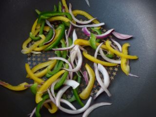 4、不用装就很嫩~黑椒羊肉披萨,热锅，把甜椒丝与洋葱丝的水份炒至8成干