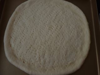 6、不用装就很嫩~黑椒羊肉披萨,把面团擀开放在烤盘内，用叉子扎上小孔