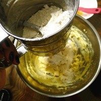 6、杏仁酥饼,筛入面粉泡打粉切拌翻拌一下。