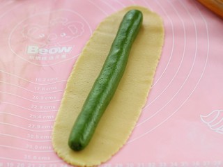 9、#曲奇菜谱秀#猫爪曲奇,把抹茶面团搓成和面片长度一样的圆柱形放到面片上