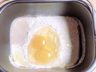 1、芝士榴莲披萨,首先我们先和面。牛奶、鸡蛋、面粉、酵母放入面包机中选择披萨面团开始和面。