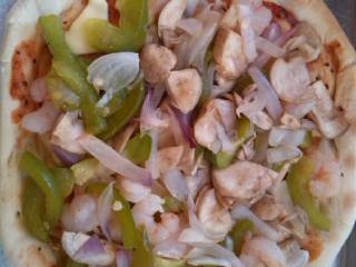 6、黑椒虾仁披萨,然后拼装披萨,放事先备好的洋葱青椒蘑菇虾仁,注意这些食材放之前最好都用烤箱烤五分钟,不然水分太大容易弄湿面饼