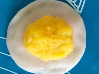 10、Q弹奶黄冰皮月饼,冷却好的奶黄馅平均分成12个奶黄馅团,将一个奶黄馅团包进冰皮里。(整体大概50g,刚好用50g的月饼模具)