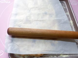 11、网红甜品+雪花酥,将糖团在烤盘里平铺,用手轻轻压实,再用擀面杖轻轻擀平。