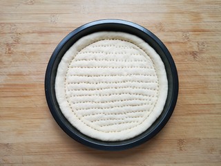 12、培根火腿披萨,用叉子扎满小孔，防止饼皮在烤制的过程中中间凸起。