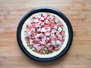 15、培根火腿披萨,再撒上火腿肠和培根肉丁。