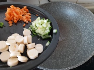 4、迷你披萨杯,热油锅倒入适量橄榄油把胡萝卜，黄瓜，肠倒进去煸炒后盛出来备用