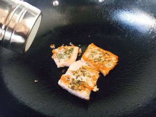 12、#懒人料理#  香煎三文鱼（快手菜）,三文鱼的一面煎10秒或者20秒左右，颜色变浅或者变成金黄色时就可以翻面，这时可以撒上少许的盐。