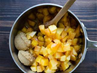 2、黄桃波旁威士忌红糖派,在炖锅里放入黄削皮、去核、切块的熟桃子 、红糖 和分开的波旁威士忌 ，煮沸后用小火慢炖并搅拌直到糖全部融化为止。