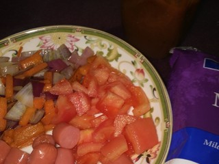 2、披萨做法,洋葱和胡萝卜切小放锅里炒熟，火腿肠和西红柿切丁